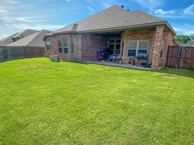 back of property featuring a patio area and a yard