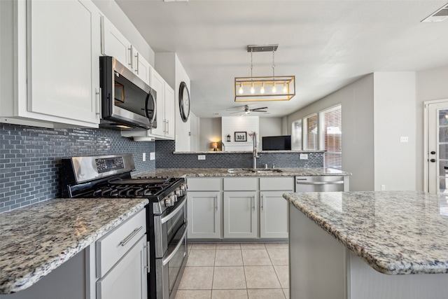 kitchen with stainless steel appliances, ceiling fan, sink, pendant lighting, and light tile patterned floors