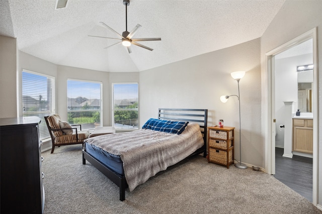 carpeted bedroom with a textured ceiling, ensuite bath, ceiling fan, and lofted ceiling