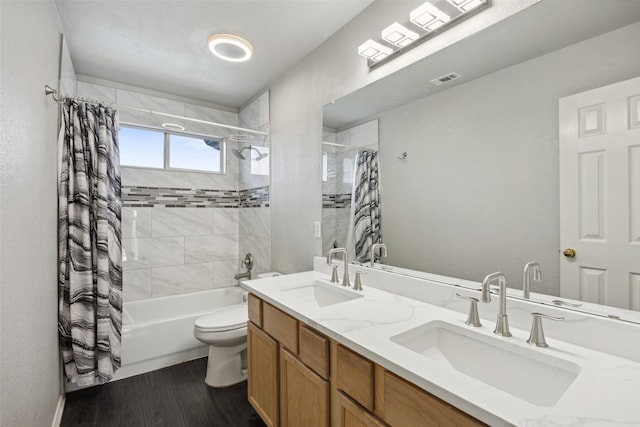 full bathroom with hardwood / wood-style flooring, shower / bath combo, toilet, and vanity