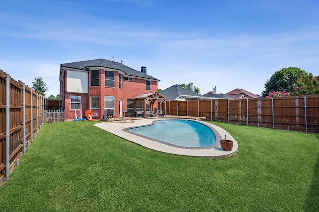 rear view of house featuring a gazebo, a fenced in pool, a patio area, and a lawn