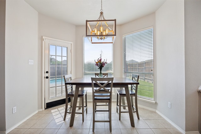 tiled dining room featuring plenty of natural light and an inviting chandelier