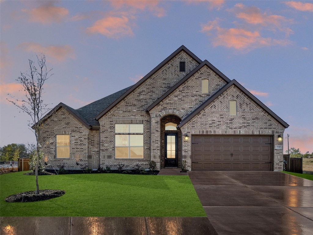 french country inspired facade with a garage and a yard