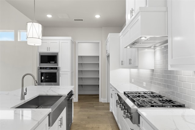 3208 Andesite Rd, Mckinney, TX 75071 - kitchen featuring appliances with stainless steel finishes, a sink, light wood finished floors, white cabinetry, and backsplash