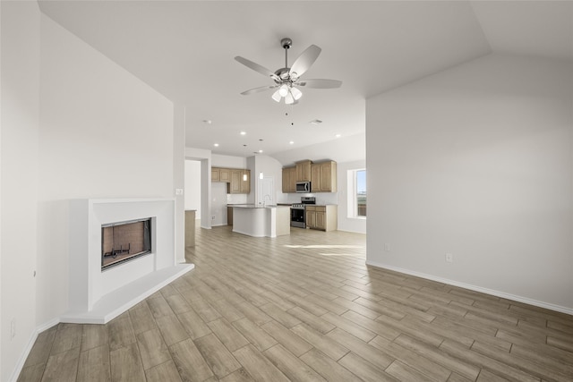 unfurnished living room featuring lofted ceiling, sink, and ceiling fan