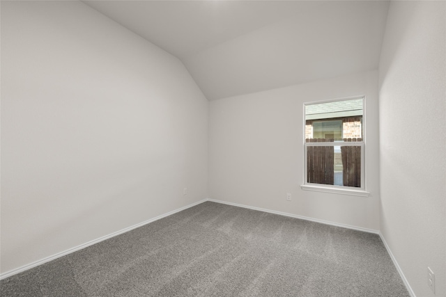 empty room with lofted ceiling and carpet