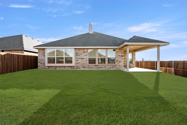 rear view of house featuring a patio area and a lawn