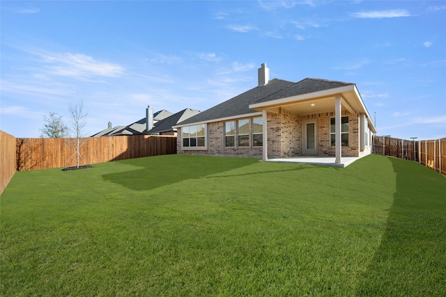 rear view of property with a yard and a patio