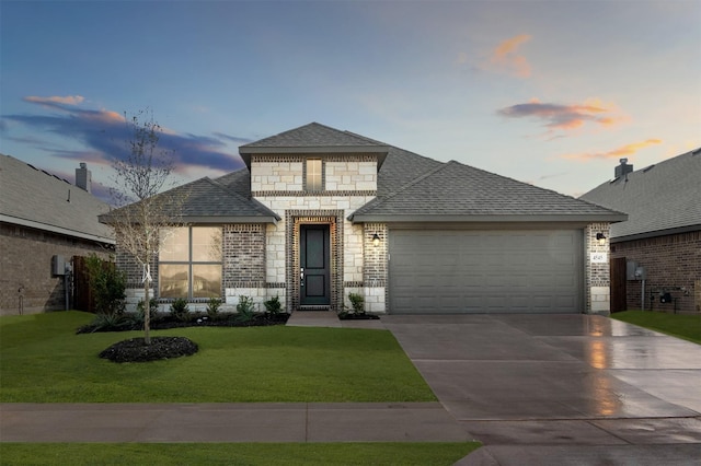 view of front of property with a garage and a yard