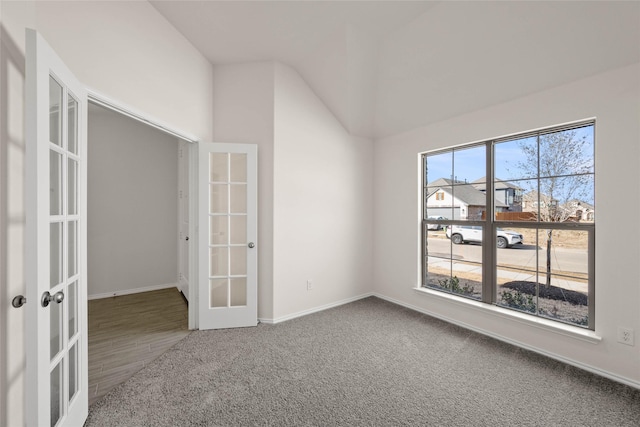 empty room with french doors, lofted ceiling, and carpet