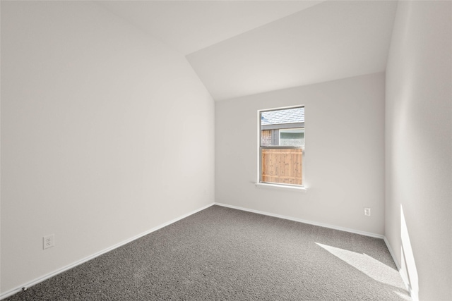 empty room with lofted ceiling and carpet flooring