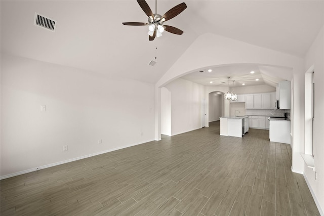 unfurnished living room with vaulted ceiling, dark wood-type flooring, and ceiling fan