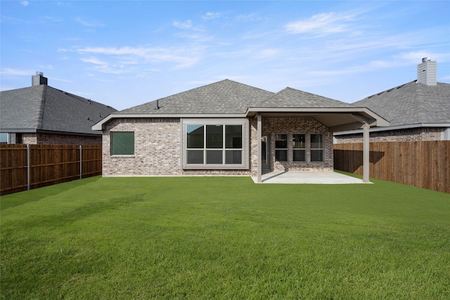 rear view of property with a lawn and a patio