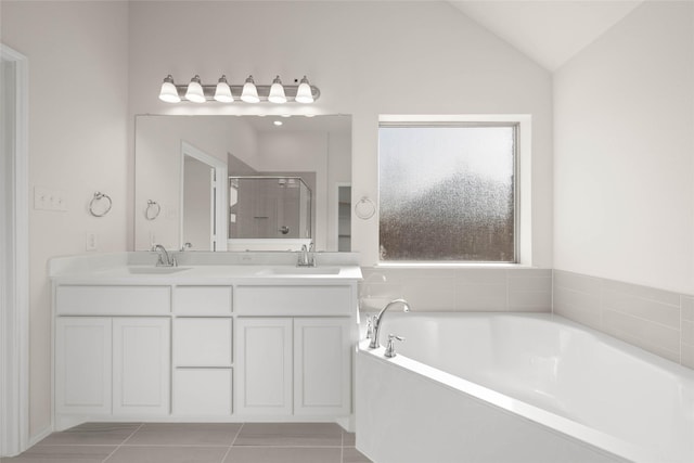 bathroom with tile patterned flooring, vaulted ceiling, separate shower and tub, and vanity