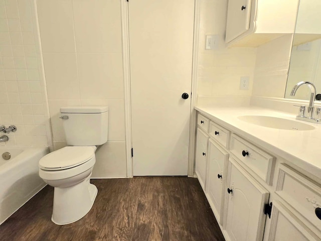 full bathroom with vanity, toilet, wood-type flooring, and tiled shower / bath