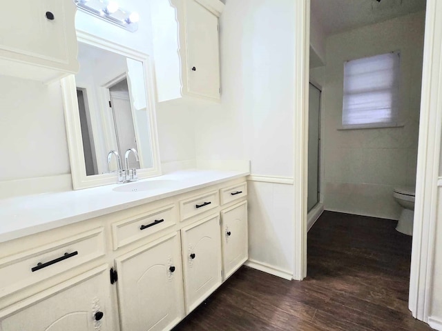 bathroom with toilet, vanity, an enclosed shower, and hardwood / wood-style flooring