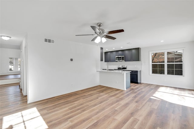 unfurnished living room with ceiling fan and light hardwood / wood-style floors