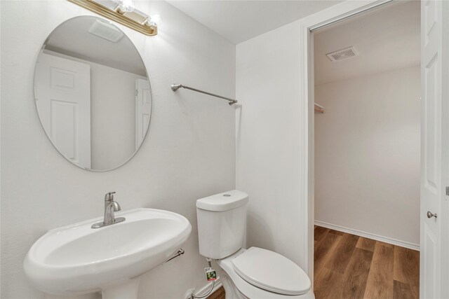 bathroom featuring hardwood / wood-style flooring, toilet, and sink