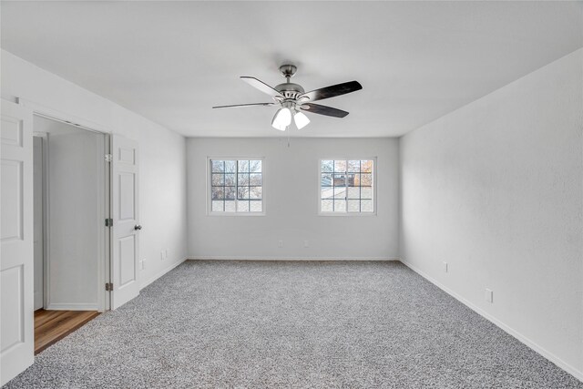 carpeted spare room featuring ceiling fan