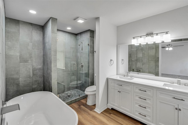 full bathroom featuring ceiling fan, toilet, vanity, independent shower and bath, and hardwood / wood-style flooring