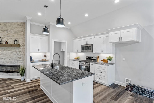 kitchen featuring pendant lighting, dark stone counters, white cabinets, sink, and stainless steel appliances