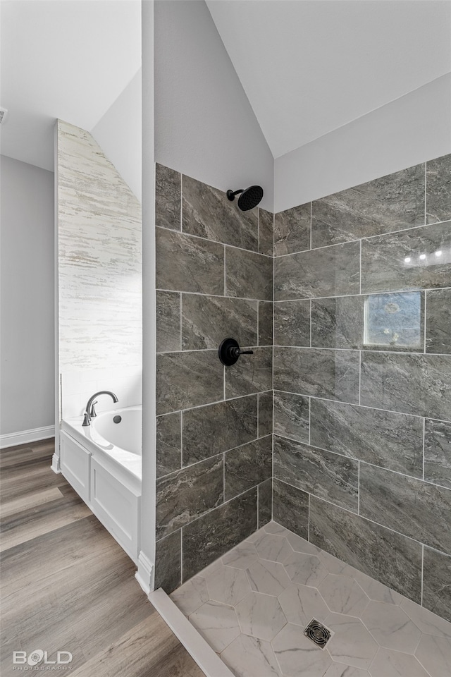 bathroom with wood-type flooring, lofted ceiling, and shower with separate bathtub