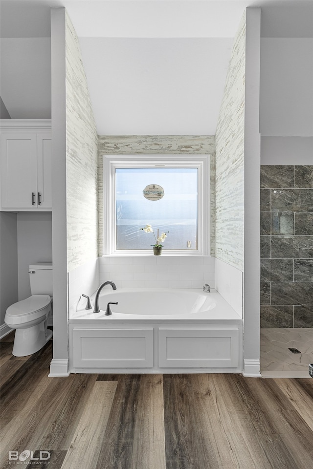 bathroom with hardwood / wood-style floors, toilet, lofted ceiling, and independent shower and bath