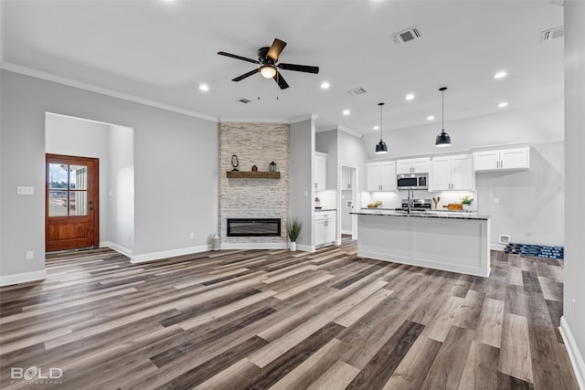 unfurnished living room with a fireplace, light hardwood / wood-style flooring, ceiling fan, and ornamental molding