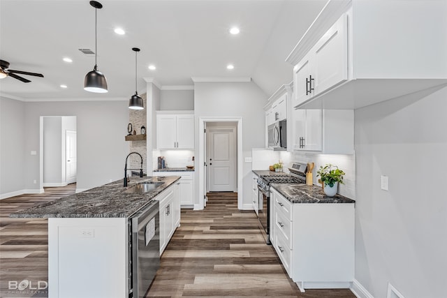 kitchen featuring appliances with stainless steel finishes, tasteful backsplash, white cabinetry, and hanging light fixtures