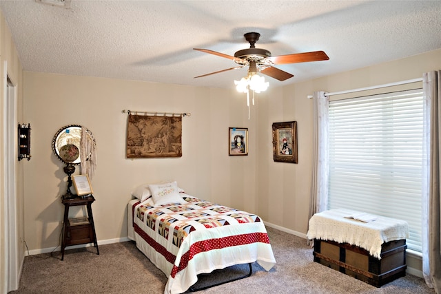 bedroom with ceiling fan, carpet, and a textured ceiling