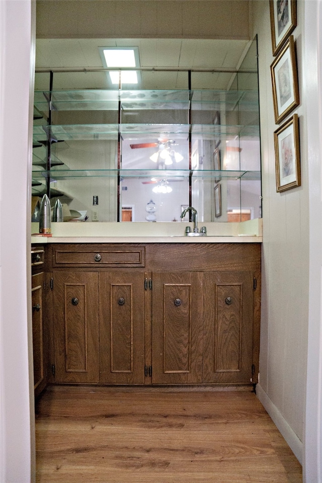 bar featuring sink and light hardwood / wood-style flooring