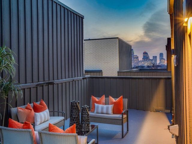 patio terrace at dusk featuring a balcony