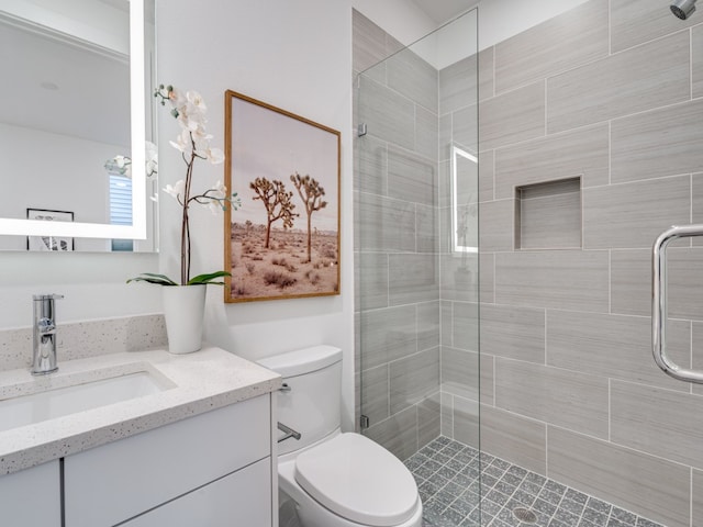 bathroom featuring vanity, an enclosed shower, and toilet