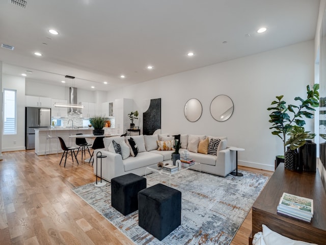 living room with light hardwood / wood-style flooring and sink