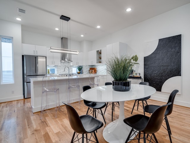 dining room with light wood-type flooring and sink