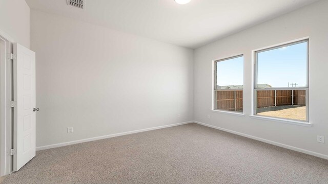 unfurnished room with baseboards, visible vents, and carpet floors