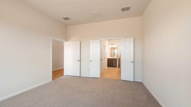 unfurnished bedroom featuring light carpet, baseboards, and visible vents