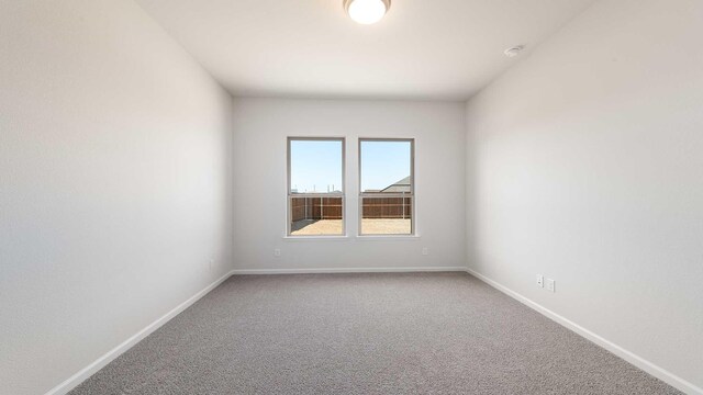 empty room featuring baseboards and carpet