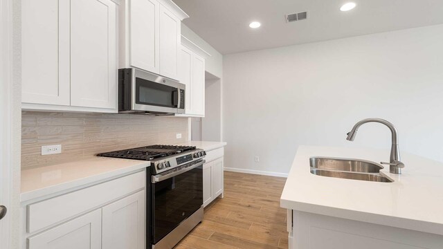 kitchen featuring light countertops, a sink, stainless steel appliances, and visible vents