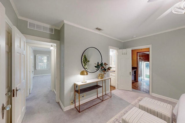 hall with light carpet, a wealth of natural light, and ornamental molding