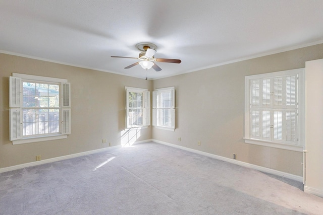 spare room with light colored carpet, ceiling fan, and crown molding