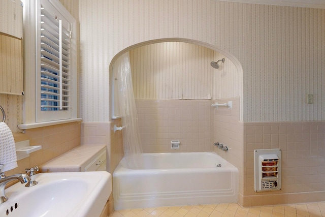 bathroom with tile patterned floors, heating unit, sink, and tiled shower / bath