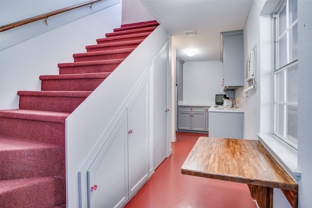 staircase with sink and concrete flooring