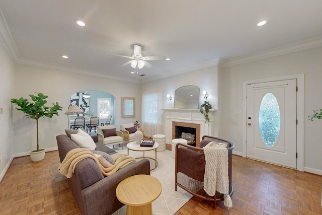 living room featuring parquet flooring, ceiling fan, and ornamental molding