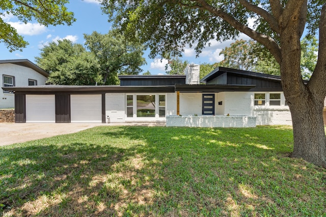 view of front of house featuring a front yard, a porch, and a garage