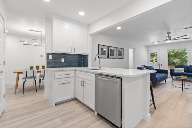 kitchen with dishwasher, sink, kitchen peninsula, light hardwood / wood-style floors, and white cabinetry