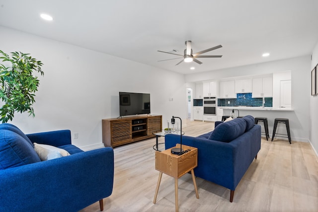 living room featuring ceiling fan and light hardwood / wood-style flooring