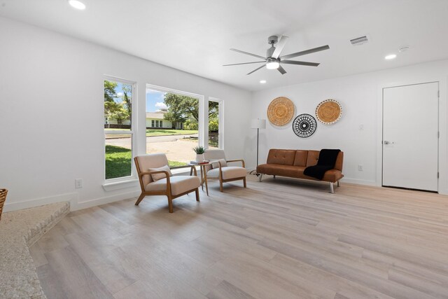 living area with ceiling fan and light wood-type flooring