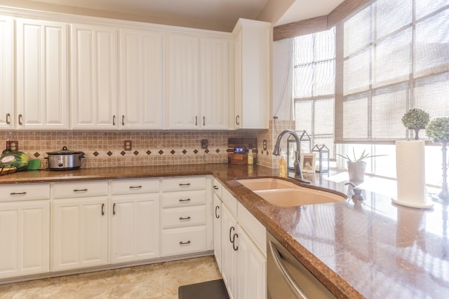 kitchen featuring backsplash, stone countertops, white cabinetry, and sink