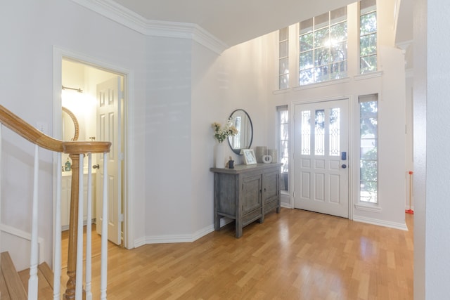 entrance foyer with crown molding and light hardwood / wood-style flooring